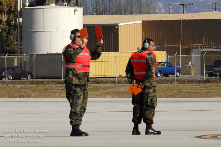 Ground crew use orange paddles